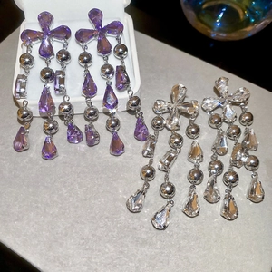Detail shot of elegant silver tassel earrings with purple and white teardrop crystals