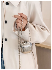 Detail of silver suitcase-style mini chain bag with vertical stripe texture