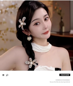 Detail of elegant pearl and rhinestone flower hair claw clips worn on a female model