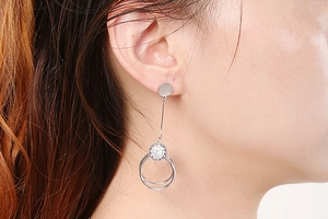 Close-up of elegant silver double-hoop earrings with sparkling crystals on model