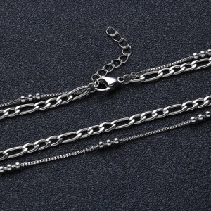 Detail of silver double-layered necklace featuring classic loop chain and bead chain texture
