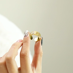 Detailed shot of gold titanium ring with vertical texture and pink zircon stones