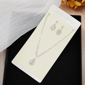 Detailed close-up of crystal bridal jewelry set with water drop pendants in a black gift box