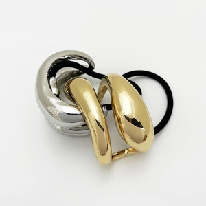 Detail of black elastic hair tie featuring mixed gold and silver intertwined metal rings