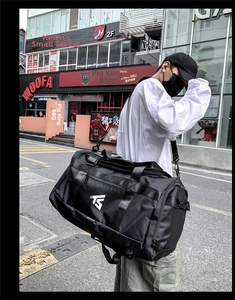 Close-up of black Oxford fabric fitness bag featuring TS logo and reinforced stitching