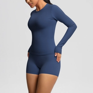 Detail view of navy blue long sleeve yoga top featuring thumbhole cuffs and slim fit design