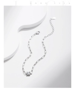 Macro detail of S925 silver paperclip link bracelet with square-cut sparkling moissanite