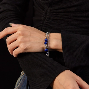 Double-layered stainless steel chain bracelet with blue tiger eye beads worn on a model