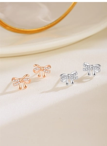 Close-up of 925 silver bow earrings in rose gold and silver with zircon pavé
