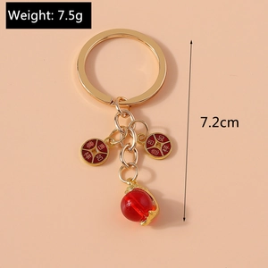 Detail showing red faux jade peanut and gold keychain with Ji Xiang Ru Yi carving