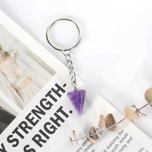 Purple amethyst hexagonal crystal keychain with silver chain on minimalist background