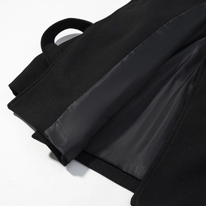 Detail of premium black wool coat showing high-quality stitching and smooth inner lining