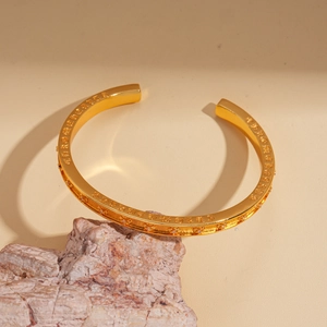 Détail du bracelet ouvert plaqué or 24K avec lettres gothiques en zircon sur pierre