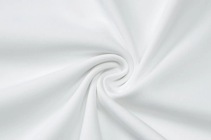 Dettaglio del tessuto in pizzo bianco con eleganti pieghe a spirale e morbide