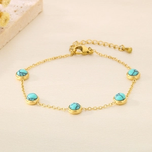 Vue détaillée d'un bracelet doré orné de cinq perles turquoise avec une chaîne d'extension
