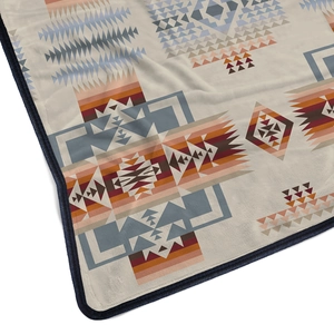 Macro detail of flannel blanket with retro geometric patterns and durable blue edge piping