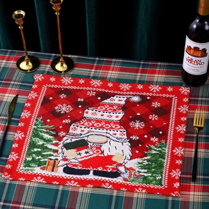 Detail of Christmas placemat with knitted faceless gnome on festive tablecloth