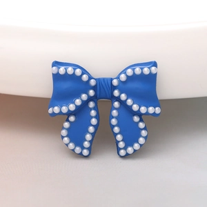 Detail of blue bow DIY accessory with white pearl trim for shoes and phone cases