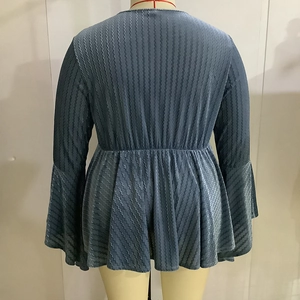 Detail view of the wavy texture fabric and flare sleeves on the back of blue V-neck top