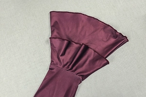 Close-up of elegant double-layered ruffled cuffs on a wine red knit bodycon dress