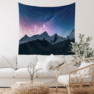 Detail of bohemian starry night tapestry hanging above a white sofa in a modern room