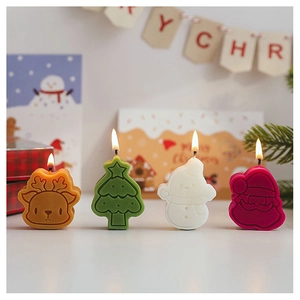 Close-up of lit Christmas candles in deer, tree, snowman, and Santa shapes on a table