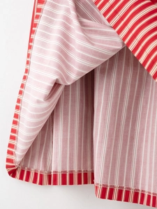 Détail de la texture du tissu à rayures rouges et blanches et couture de l'ourlet de jupe