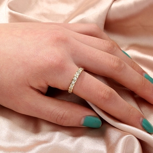Close-up of gold paperclip ring featuring quilted texture and pavé zircon settings