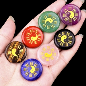 Handheld set of seven colorful natural gemstone discs with golden Bagua symbols
