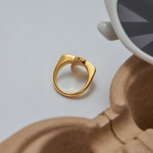 Macro detail of gold irregular geometric star ring with high polish finish and sharp edges