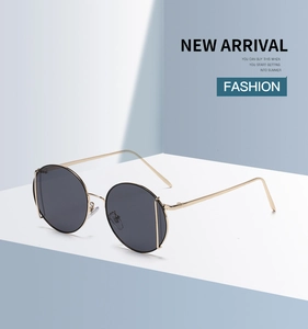 Detailed close-up of golden metal round sunglasses with dark lenses and slim temples
