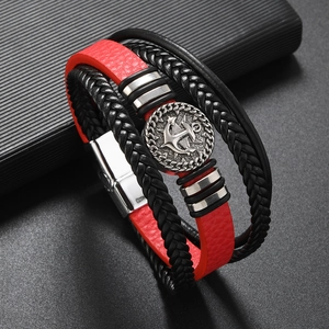 Close-up of multilayer red and black leather bracelet with metal anchor charm and buckle