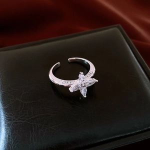 Macro detail of silver open ring with marquise-cut zircon stones on silk background