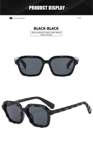Close-up of glossy black fashion sunglasses with unique wavy textured frames and dark grey lenses