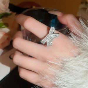 Detailed view of silver bow ring with cubic zirconia stones on model finger