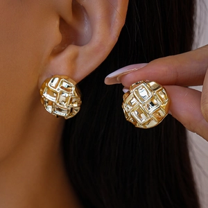 Vue détaillée de boucles d'oreilles rondes dorées avec motif gaufré sur un mannequin