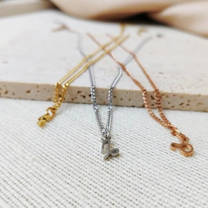 Detailed view of zodiac pendant necklaces in gold, silver, and rose gold finishes