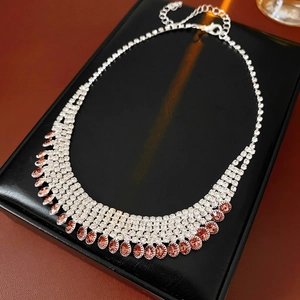 Detail of tear-drop pink rhinestone necklace with adjustable lobster clasp on black pad