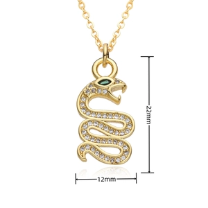 Detailed view of gold snake pendant with green stone eyes and micro-set rhinestones