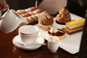 Close-up of DIY afternoon tea miniature set featuring elegant teacups and french desserts