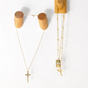 Détails des pendentifs croix, œil maléfique et colibri sur chaînes dorées fines