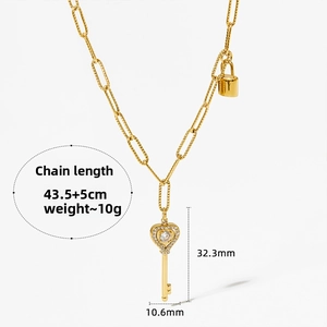 Macro detail of gold heart key pendant with sparkling crystals and size specifications