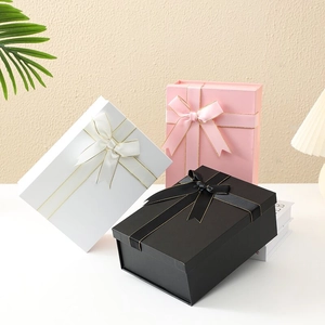 Set of black, pink, and white folding gift boxes with gold-edged ribbon bows