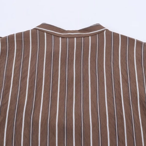 Nahaufnahme des braun gestreiften Hemdkragens und der Schulternähte auf weißem Hintergrund