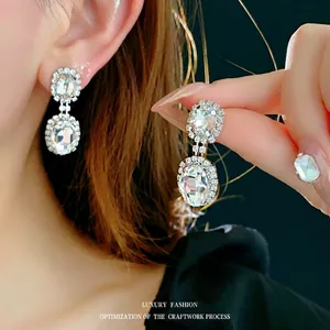 Elegant silver-tone long drop earrings featuring large oval crystals and halo diamond accents