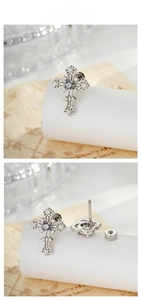 Detailed view of silver cross earrings with crystal inlay and screw-back closure