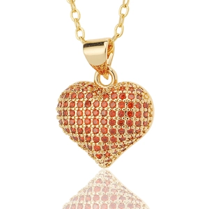 Macro shot of 3D heart pendant with red micro-pave zircons and gold-plated chain