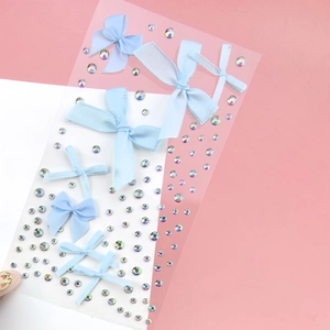 Close-up of light blue fabric bows and iridescent rhinestones for facial makeup and eye art