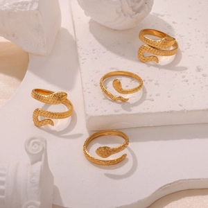Gold plated snake ring with engraved scales shown from multiple angles on a stone surface