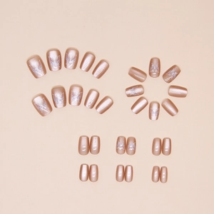 Detailed flat lay of champagne cat-eye press-on nails with white butterfly patterns